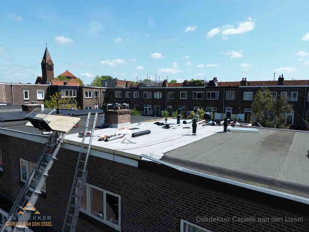 Dakdekkers aan het werk op plat dak in Capelle aan den IJssel