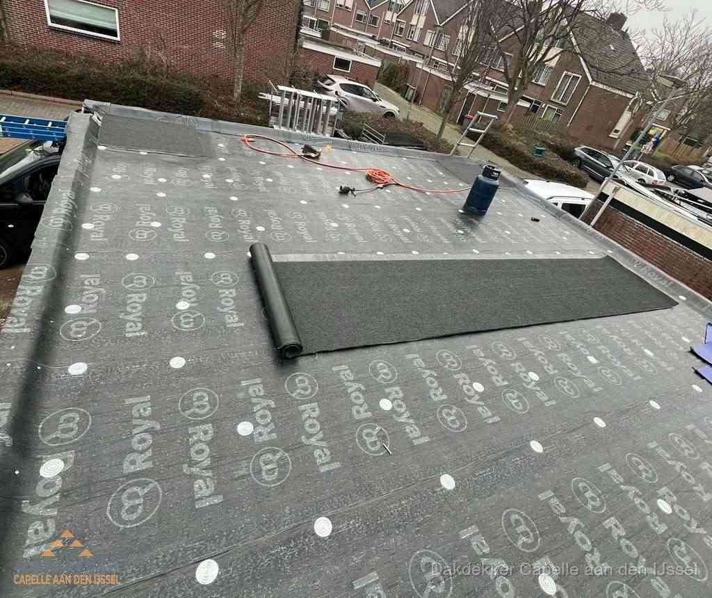 Dakdekker aan het werk met gasbrander op plat bitumen dak in Capelle aan den IJssel