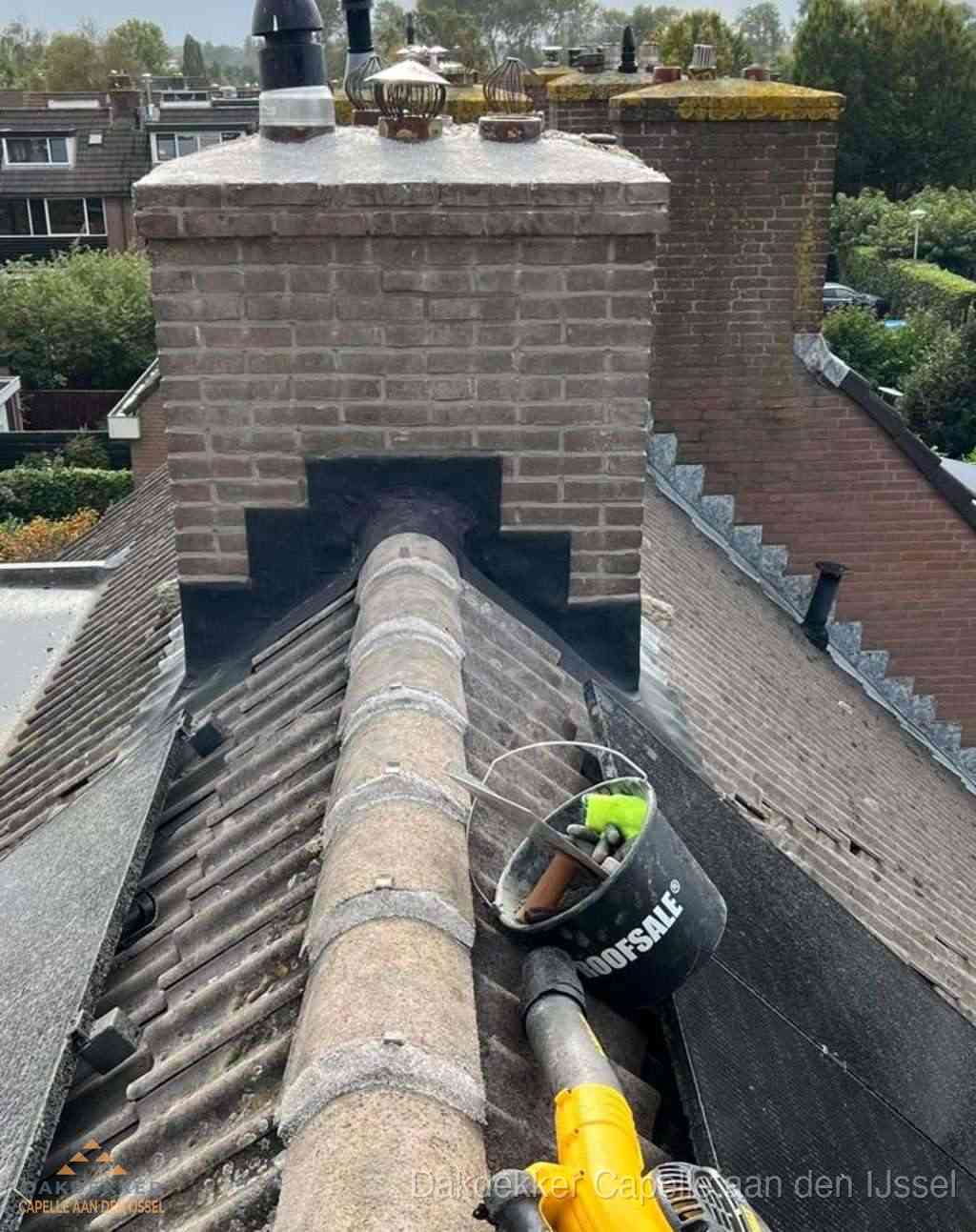 Dakdekker repareert bitumen dakleer bij dakdoorvoer in Capelle aan den IJssel